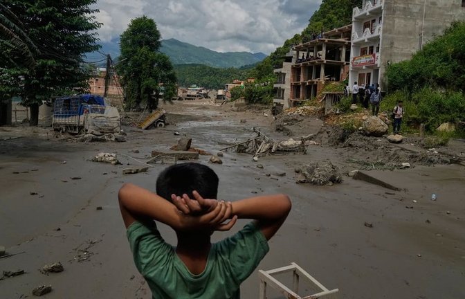 Ein Junge betrachtet die Verwüstungen, die durch Sturzfluten am Fluss Trishuli im nepalesischen Distrikt Nuwakot verursacht wurden. Nach der heftigen Sturzflut in der Grenzregion zwischen China und Nepal gibt es mehrere Tote, nach Behördenangaben werden Hunderte Touristen vermisst.<span class='image-autor'>Niranjan Shrestha/AP/dpa</span>