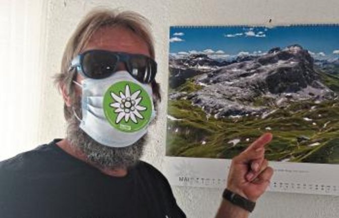 Mit DAV-Maske heißt der Sektionsvorsitzende Roland Fischer Besucher willkommen. Foto: p
