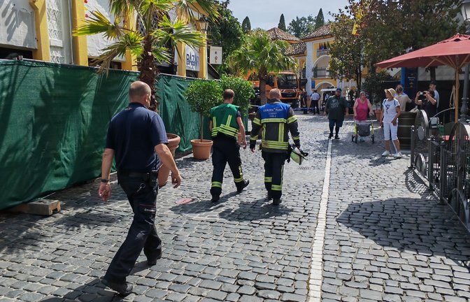 Hinter der grünen Absperrung sind die Überreste des Brands noch zu erkennen. Die Einsatzkräfte arbeiten bei Betrieb des Parks.<span class='image-autor'>Foto: Erdem Gökalp</span>