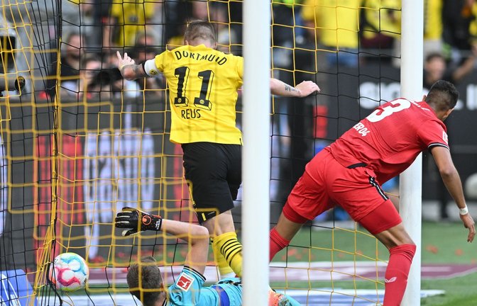 Dortmunds Marco Reus (M) stochert den Ball gegen Leverkusens Torwart Lukas Hradecky (l) und Piero Hincapie über die Linie.<span class='image-autor'>Foto: Bernd Thissen/dpa</span>