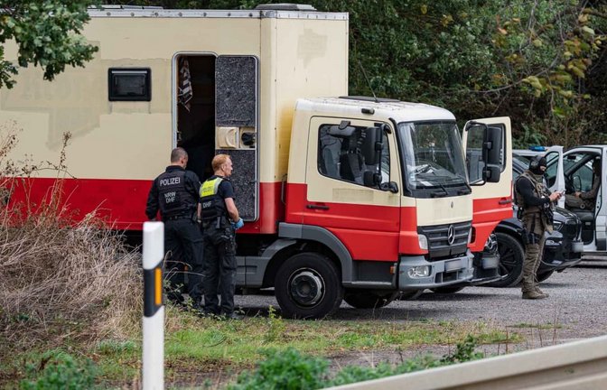 Polizisten in Spezialausrüstung sind an einem Lkw im Einsatz. Die Polizei hat laut NRW-Innenminister Reul in Niederzier das Fahrzeug des Verdächtigen für mehrere Sabotageaktionen gegen die deutsche Stromversorgung gestürmt.<span class='image-autor'>Daniel Evers/WupperVideo/dpa</span>