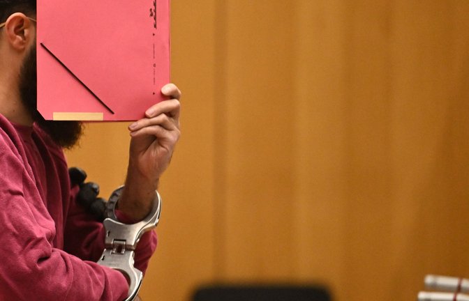 Der Polizistenmörder Sulaiman A. versteckt an einem Prozesstag vor dem Stuttgarter Oberlandesgericht sein Gesicht hinter einer Mappe.<span class='image-autor'>Foto: Marijan Murat/dpa</span>
