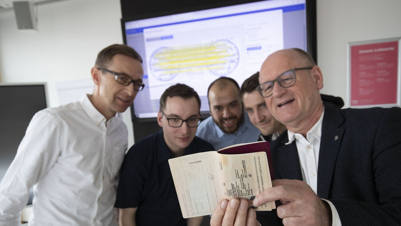Professor Johannes Maucher, Patrick Takenaka, Manuel Eberhardinger, Daniel Grießbauer und Kriminalist Rolf Fauser (v.l.) begutachten einen Reisepass: künstliche Intelligenz trainieren.Foto: Lichtgut//Leif Piechowski Professor Johannes Maucher, Patrick Takenaka, Manuel Eberhardinger, Daniel Grießbauer und Kriminalist Rolf Fauser (v.l.) begutachten einen Reisepass: künstliche Intelligenz trainieren.Foto: Lichtgut//Leif Piechowski