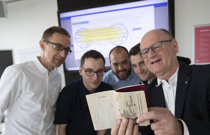 Professor Johannes Maucher, Patrick Takenaka, Manuel Eberhardinger, Daniel Grießbauer und Kriminalist Rolf Fauser (v.l.) begutachten einen Reisepass: künstliche Intelligenz trainieren.<span class='image-autor'>Foto: Lichtgut//Leif Piechowski</span>