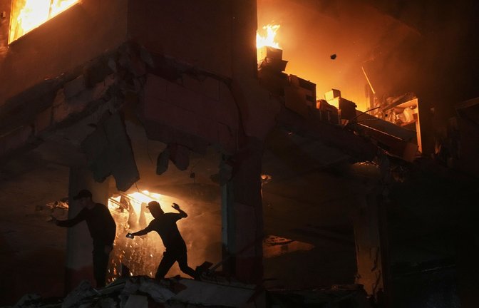 Palästinenser reagieren auf ein Feuer nach einem israelischen Angriff auf ein Wohnhaus im Stadtteil Rimal in Gaza Stadt.<span class='image-autor'>Foto: Jehad Alshrafi/AP/dpa</span>