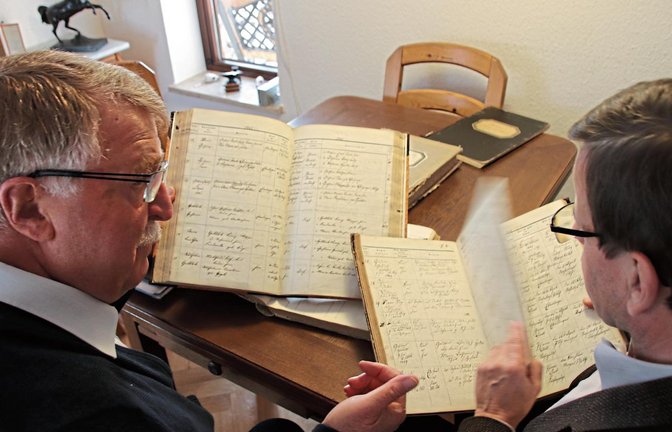 Ernst Kranich (links) und der Pfarrer Hans-Jürgen Neumann mit Eberdinger Kirchenbüchern. Fotos: Arning