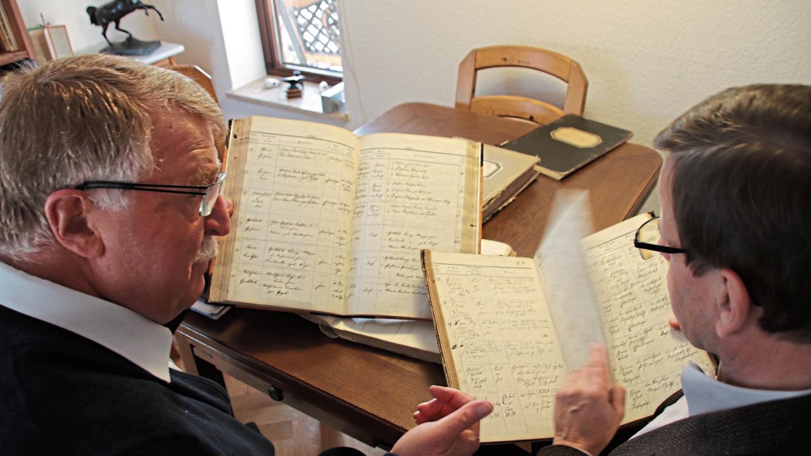 Ernst Kranich (links) und der Pfarrer Hans-Jürgen Neumann mit Eberdinger Kirchenbüchern. Fotos: Arning