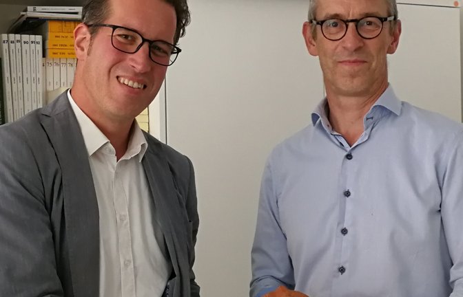 Dr. Henk Vandaele (rechts) überreicht Dr. Simon Karzel die Ton-Skulptur.  <span class='image-autor'>Foto: p</span>