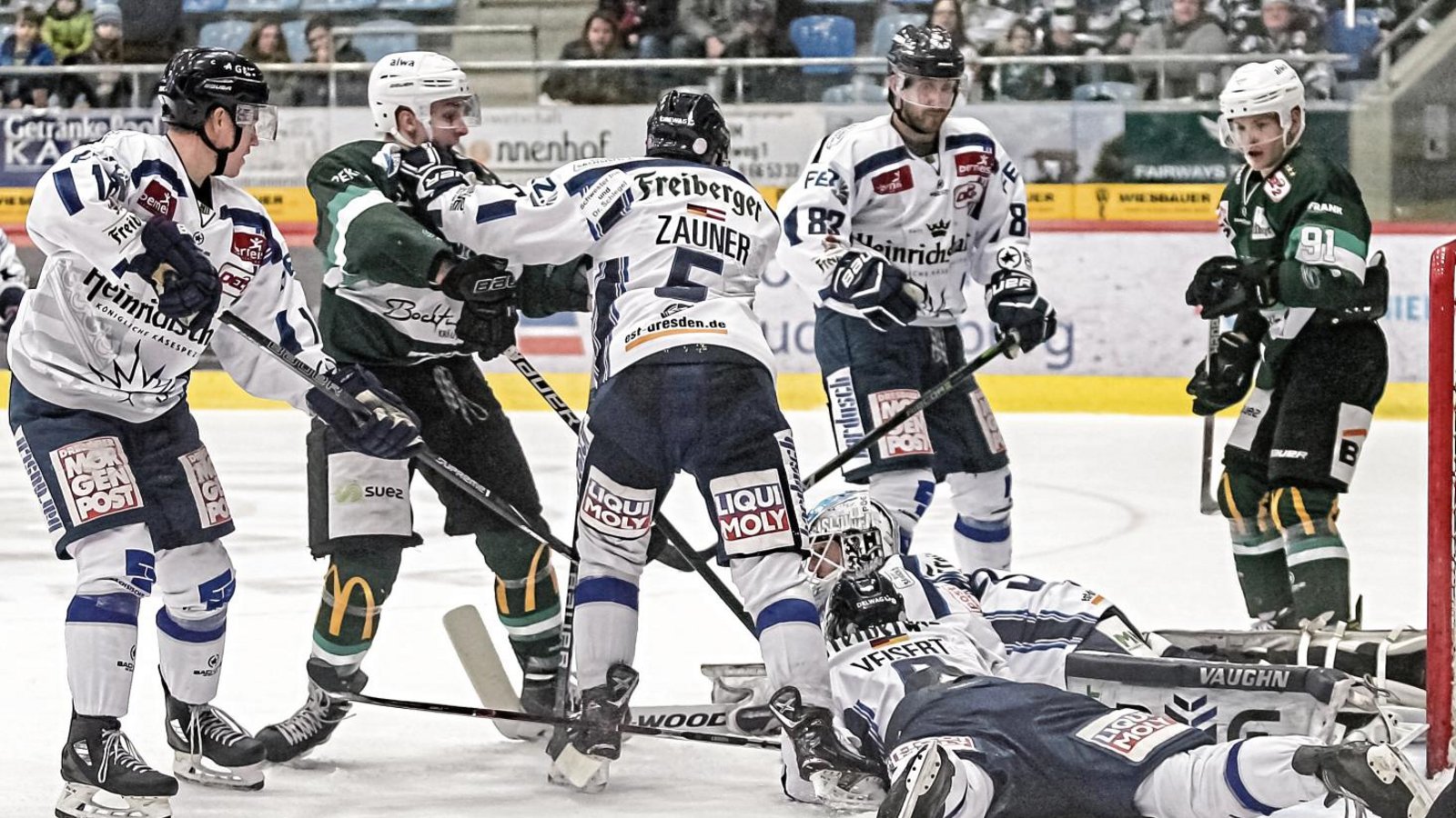 Die Dresdner Timo Walther (links), Sebastian Zauner (Mitte) und Gustav Veisert (Zweiter von rechts stehend) schützen ihren Goalie Marco Eisenhut (am Boden) vor dem Bietigheimer Max Lukes (Zweiter von links), der versucht, an den Puck zu kommen, obwohl der unter dem Torwart begraben ist. Foto: Simecek