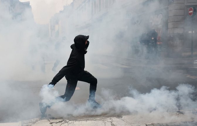 In Rennes wirft ein Demonstrant eine Tränengasgranate in Richtung der Polizei. Je nach Darstellung gingen am Samstag zwischen 400.000 und 800.000 Menschen in Frankreich auf die Straße.<span class='image-autor'>Jeremias Gonzalez/dpa</span>
