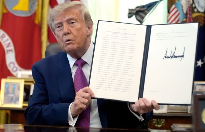 Donald Trump, Präsident der USA, hält im Oval Office des Weißen Hauses eine unterzeichnete Executive Order in die Höhe.<span class='image-autor'>Manuel Balce Ceneta/AP/dpa</span>