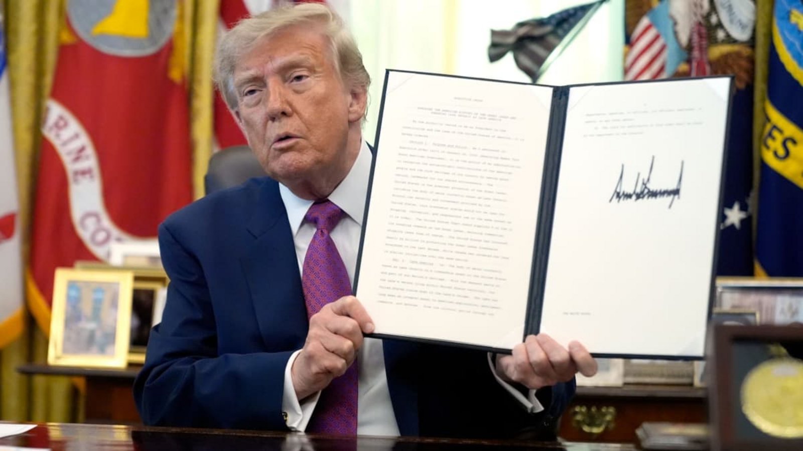 Donald Trump, Präsident der USA, hält im Oval Office des Weißen Hauses eine unterzeichnete Executive Order in die Höhe.Manuel Balce Ceneta/AP/dpa