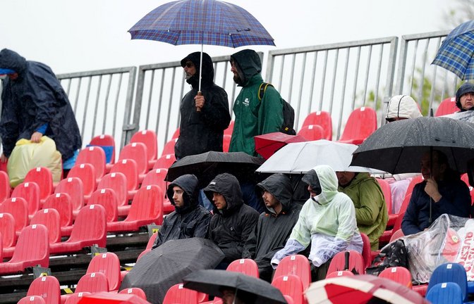 Fans sitzen während des Freien Trainings mit Regenschirmen auf der Tribüne.<span class='image-autor'>Foto: David Davies/PA Wire/dpa</span>