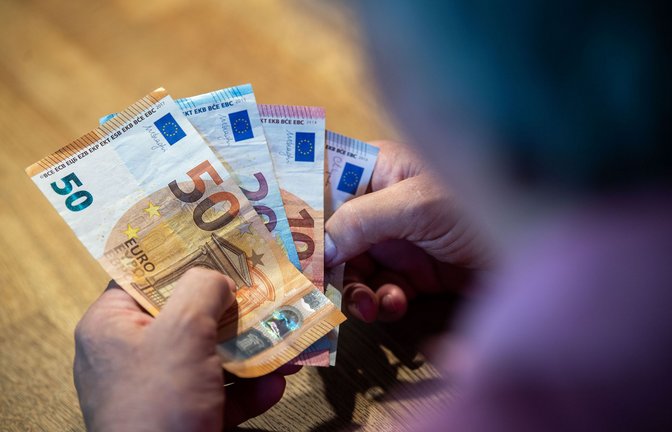 Ein Rentner  sitzt an einem Tisch und zählt Geld. Fast die Hälfte der Menschen in Deutschland macht sich einer Umfrage zufolge Sorgen um ihre finanzielle Lage im Alter.<span class='image-autor'>Foto: dpa/Lino Mirgeler</span>