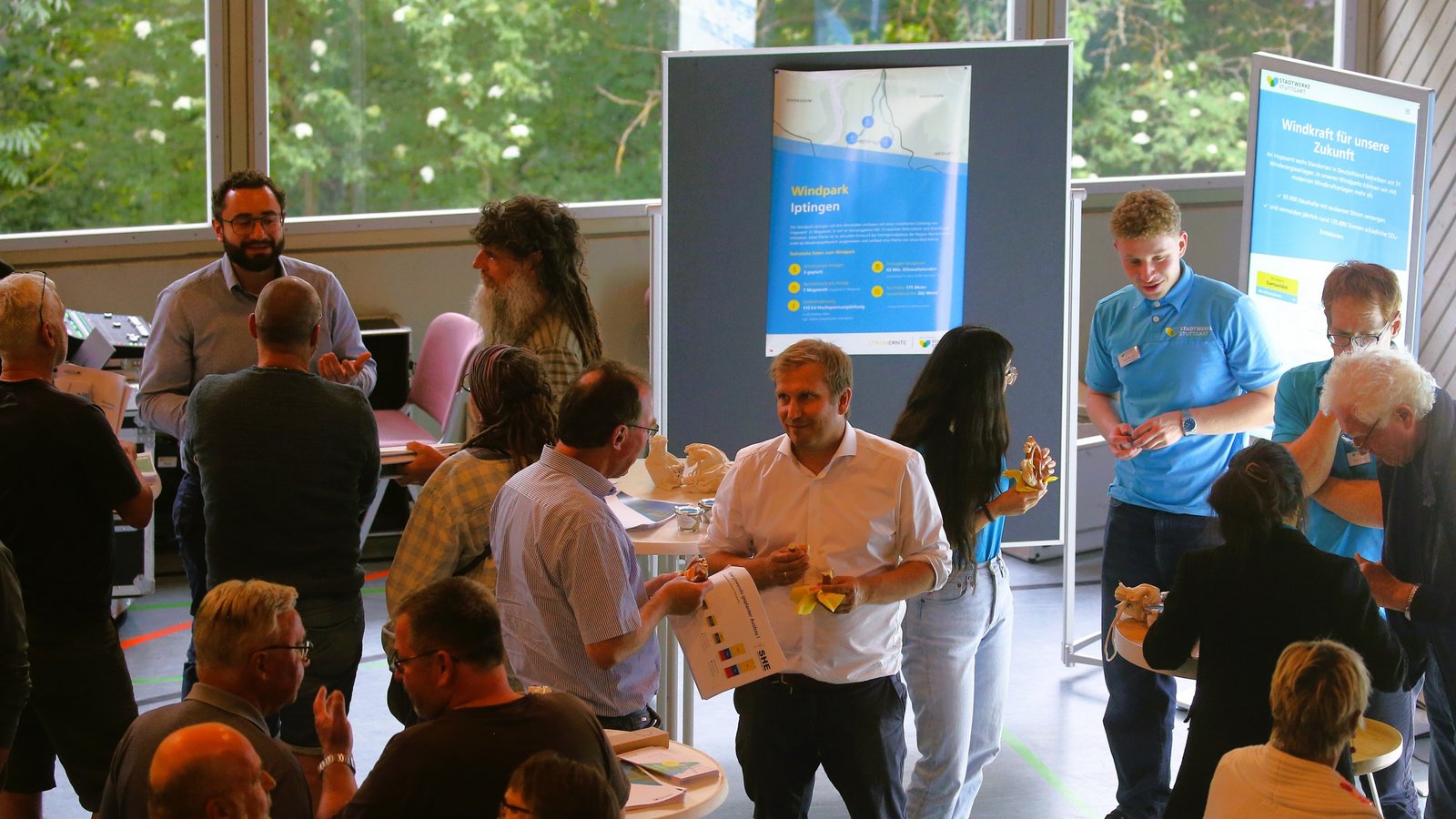 Bürger und Beteiligte kommen bei der Windkraft-Infoveranstaltung in der Iptinger Kreuzbachhalle miteinander ins Gespräch. Foto: Küppers Bürger und Beteiligte kommen bei der Windkraft-Infoveranstaltung in der Iptinger Kreuzbachhalle miteinander ins Gespräch. Foto: Küppers