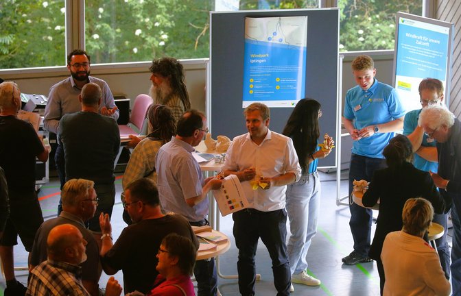Bürger und Beteiligte kommen bei der Windkraft-Infoveranstaltung in der Iptinger Kreuzbachhalle miteinander ins Gespräch. <span class='image-autor'>Foto: Küppers</span>