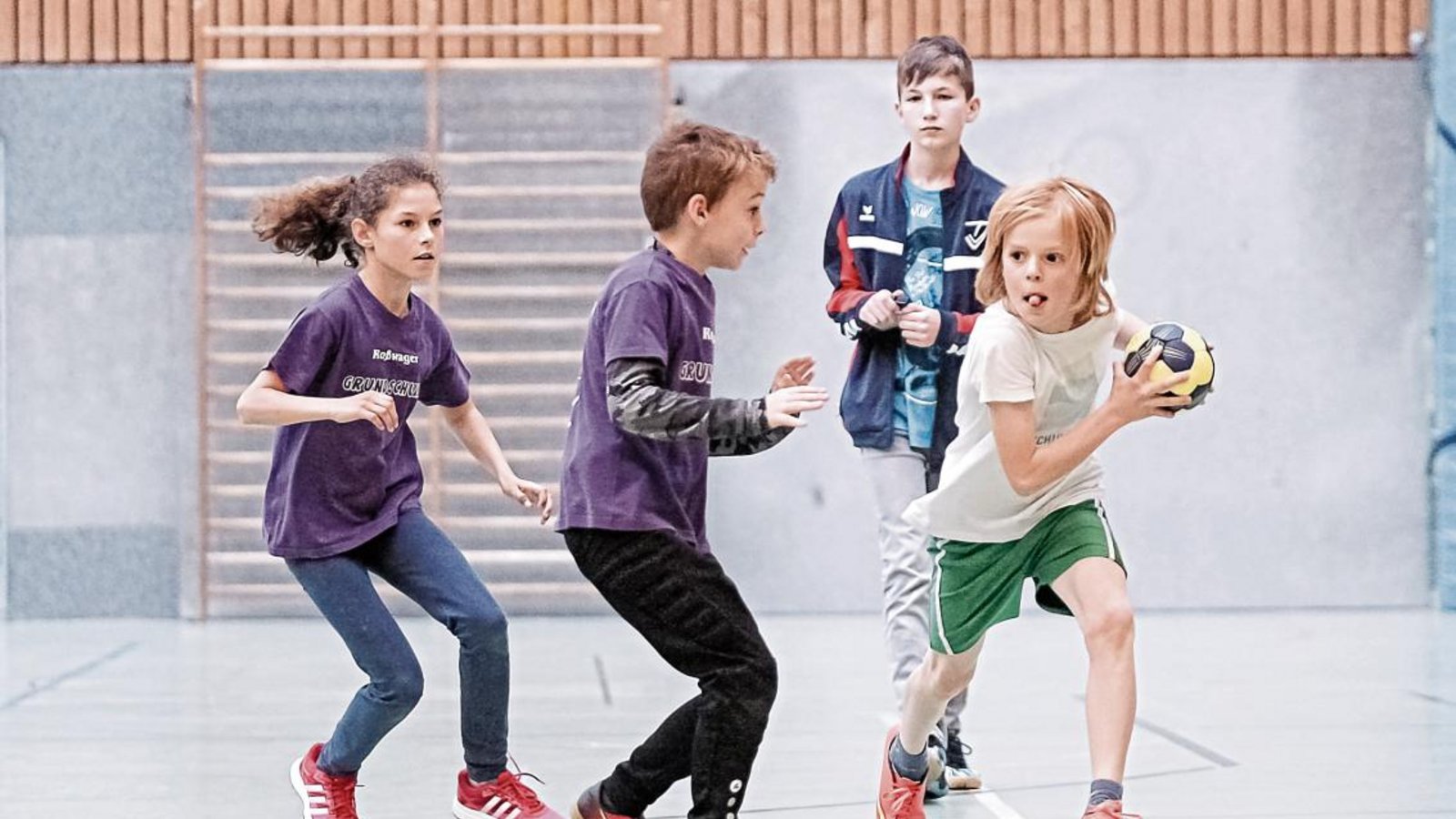 Wettbewerb der vierten Klassen: Die Grundschule Roßwag (in Lila) will an den Ball, doch den hat im Moment Aurich in Besitz. Foto: Simecek