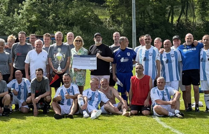 Doppeltorschütze Andreas Bahmer präsentiert den Pokal, während Michael Bofinger (Mitte rechts) den Spendenscheck an die Schirmherrin Sabrina Sailer von der Lebenshilfe übergibt.