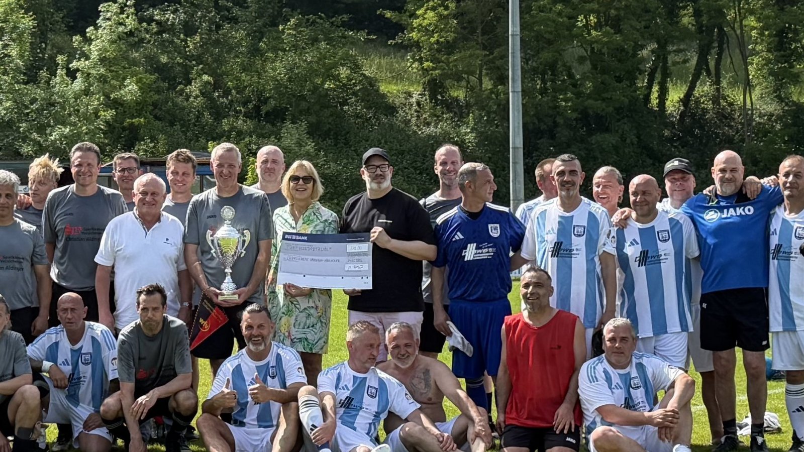Doppeltorschütze Andreas Bahmer präsentiert den Pokal, während Michael Bofinger (Mitte rechts) den Spendenscheck an die Schirmherrin Sabrina Sailer von der Lebenshilfe übergibt. Doppeltorschütze Andreas Bahmer präsentiert den Pokal, während Michael Bofinger (Mitte rechts) den Spendenscheck an die Schirmherrin Sabrina Sailer von der Lebenshilfe übergibt.