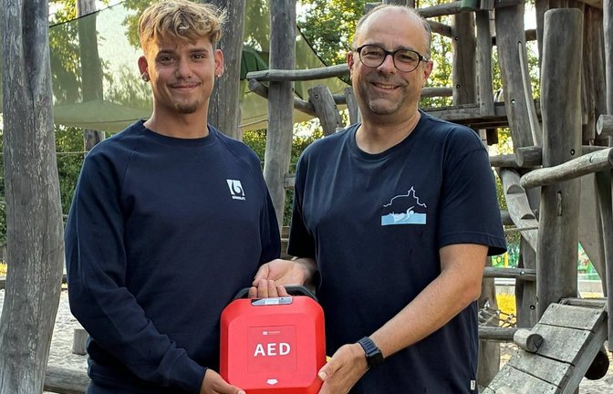 Eine lebensrettende Spende: Der Leiter des Enztalbads, Luan Gashi (links), nimmt von Tobias Mäule vom Förderverein den neuen AED entgegen. Foto: p