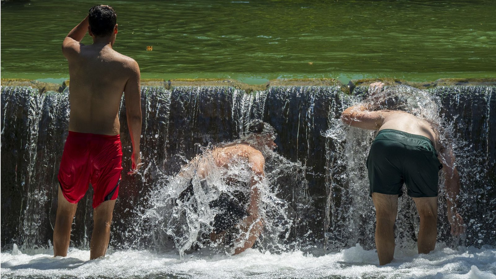 Jugendliche kühlen sich im Eisbach im Englischen Garten ab.Foto: Peter Kneffel/dpa