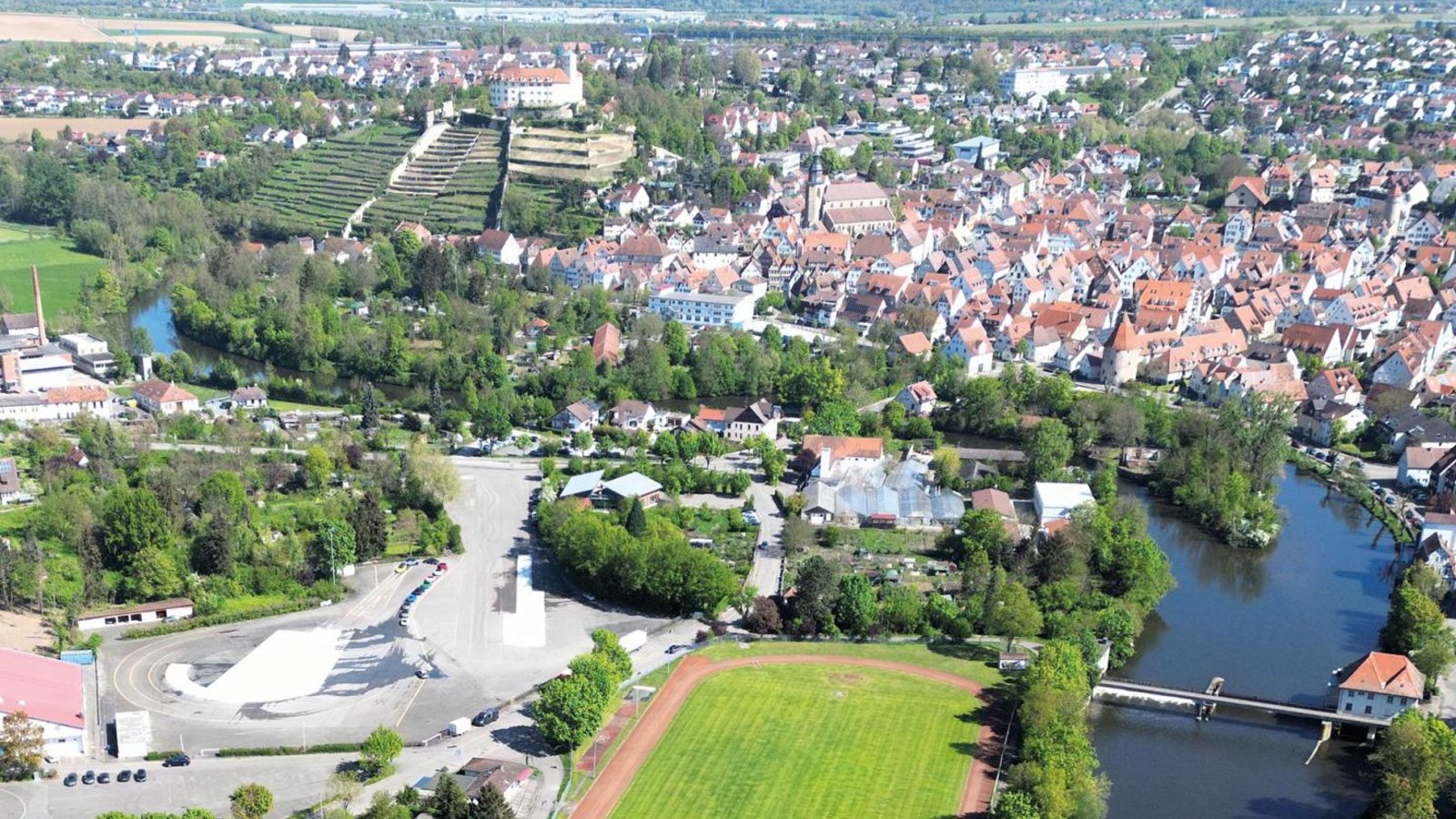 Hier wird sich bis 2029 einiges tun: Das Areal der künftigen Gartenschau Vaihingen umfasst unter anderem das brachliegende Gelände der ehemaligen Leimfabrik Häcker (auf dem Bild: Mitte links), die gegenüberliegenden historischen Bürgergärten, das Areal der ehemaligen Gärtnerei Weller (oberhalb des Sportplatzes) sowie die künftigen Enzterrassen mit den zu überplanenden Sportanlagen Egelsee.  Archivfoto: Küppers