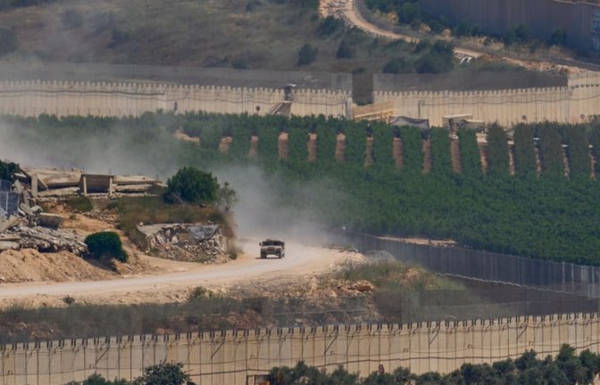 Ein israelisches Militärfahrzeug fährt an zerstörten Gebäuden im Südlibanon vorbei, aufgenommen aus Nordisrael (Archivfoto).<span class='image-autor'>Ohad Zwigenberg/AP/dpa</span>