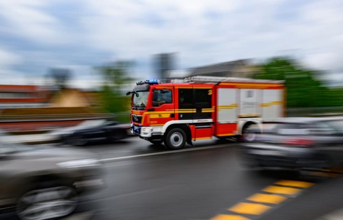 Eine Feuerwehrfahrzeug fährt mit Blaulicht zu einem Einsatz.<span class='image-autor'>Robert Michael/dpa</span>