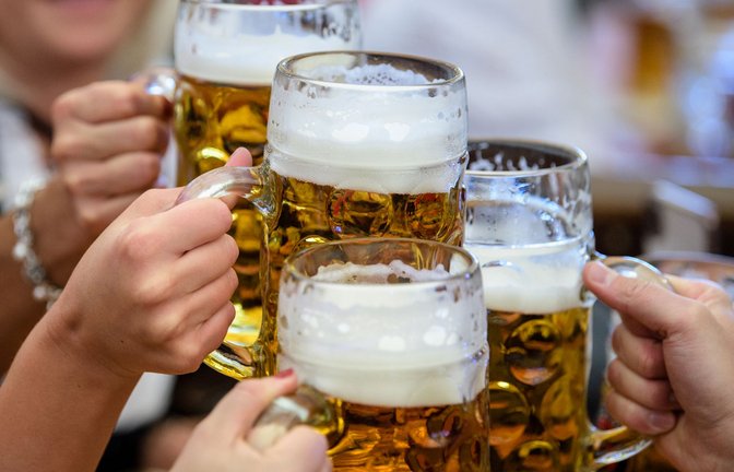 Besucher stoßen auf dem Oktoberfest in München mit einem Humpen Bier an.<span class='image-autor'>Foto: dpa/Matthias Balk</span>