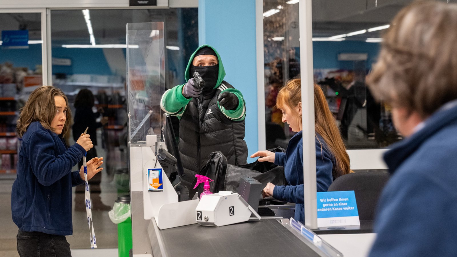 Überfall auf einen Discounter. Der Täter im grünen Jogginganzug bedroht die Angestellten. Doch dann stören Zeugen die Tat.Foto: ZDF/Saskia Pavek Überfall auf einen Discounter. Der Täter im grünen Jogginganzug bedroht die Angestellten. Doch dann stören Zeugen die Tat.Foto: ZDF/Saskia Pavek
