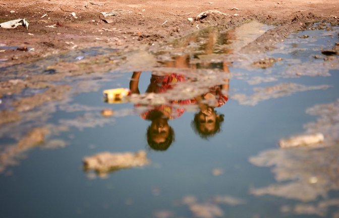 Kinder sitzen auf einer mit Abwasser überfluteten Straße in Deir el-Balah. Im Gazastreifen infizierte sich erstmals seit mehr als zwei Jahrzehnten wieder ein Kind mit dem Poliovirus (Archivfoto).<span class='image-autor'>Foto: IMAGO/NurPhoto/IMAGO/Majdi Fathi</span>