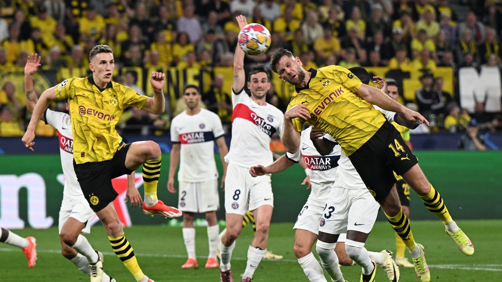 Dortmunds Niclas Füllkrug (r) kommt zum Kopfball - er erziehlt gegen Paris Saint-Germain das entscheidende Tor in der Champions League.Foto: Federico Gambarini/dpa