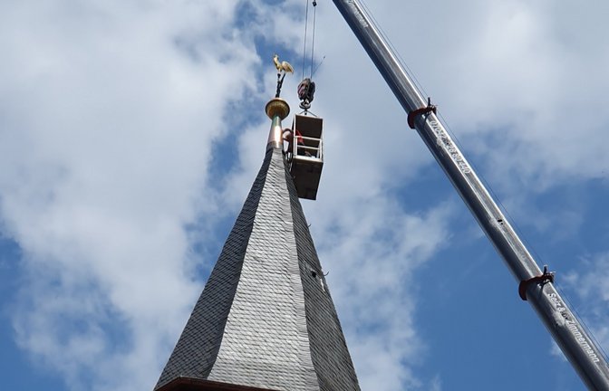 Die Dachdecker lassen es funkeln am Kirchturm in Enzweihingen mit dem neuen Kegel aus Kupfer.  <span class='image-autor'>Foto: Berner</span>