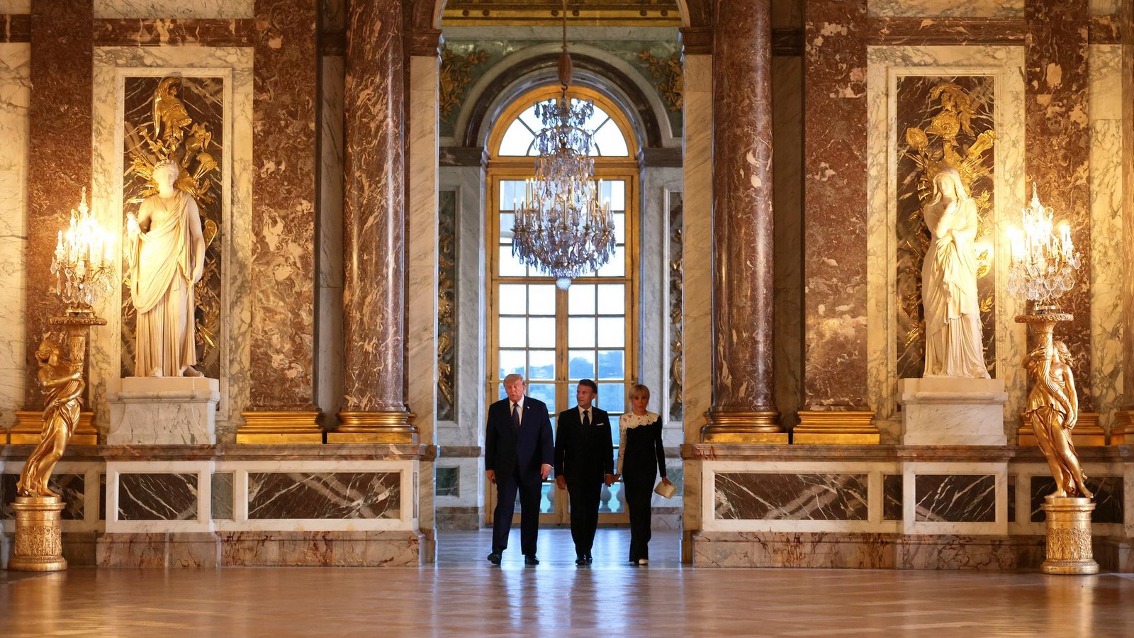 US-Präsident Donald Trump (l) wird vor einem gemeinsamen Abendessen vom französischen Präsidenten Emmanuel Macron und dessen Ehefrau Brigitte Macron durch das Schloss Versailles geführt.Foto: Anna Moneymaker/Pool Getty Images/AP/dpa