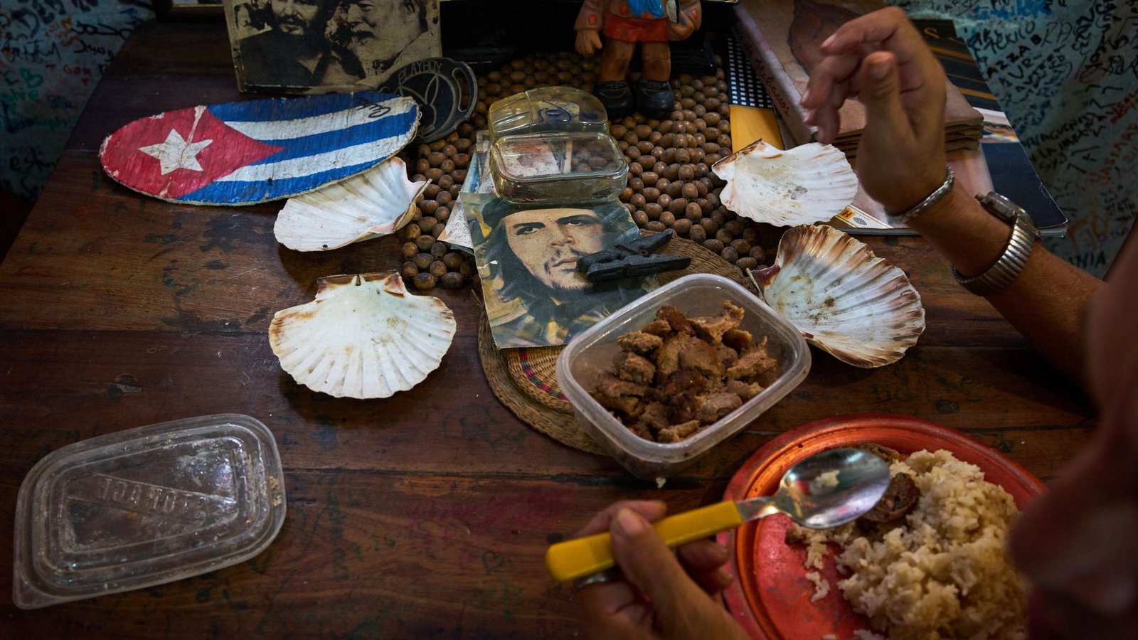 Eine Angestellte eines Souvenirgeschäfts in Havanna isst neben Bildern von Che Guevara, Fidel Castro und Ernest Hemingway.Foto: Ramon Espinosa/AP/dpa Eine Angestellte eines Souvenirgeschäfts in Havanna isst neben Bildern von Che Guevara, Fidel Castro und Ernest Hemingway.Foto: Ramon Espinosa/AP/dpa