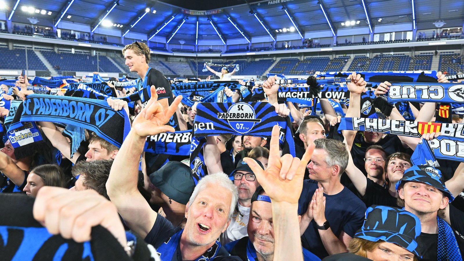Die Zuschauer im Stadion feiern und halten Schals in die Höhe.Foto: Swen Pförtner/dpa