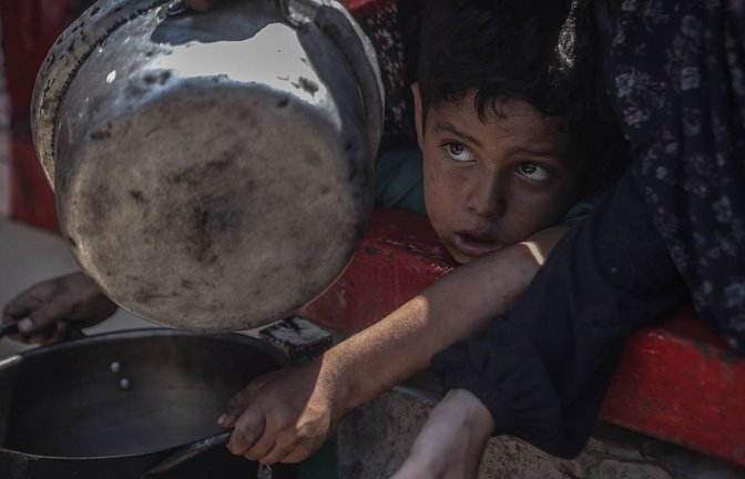 Palästinensisches Kind mit einer Pfanne in der Hand: Hungerleidende Palästinenserinnen und Palästinenser im Gazastreifen versuchen, an Essen zu kommen.<span class='image-autor'>Foto: IMAGO/Anadolu Agency</span>