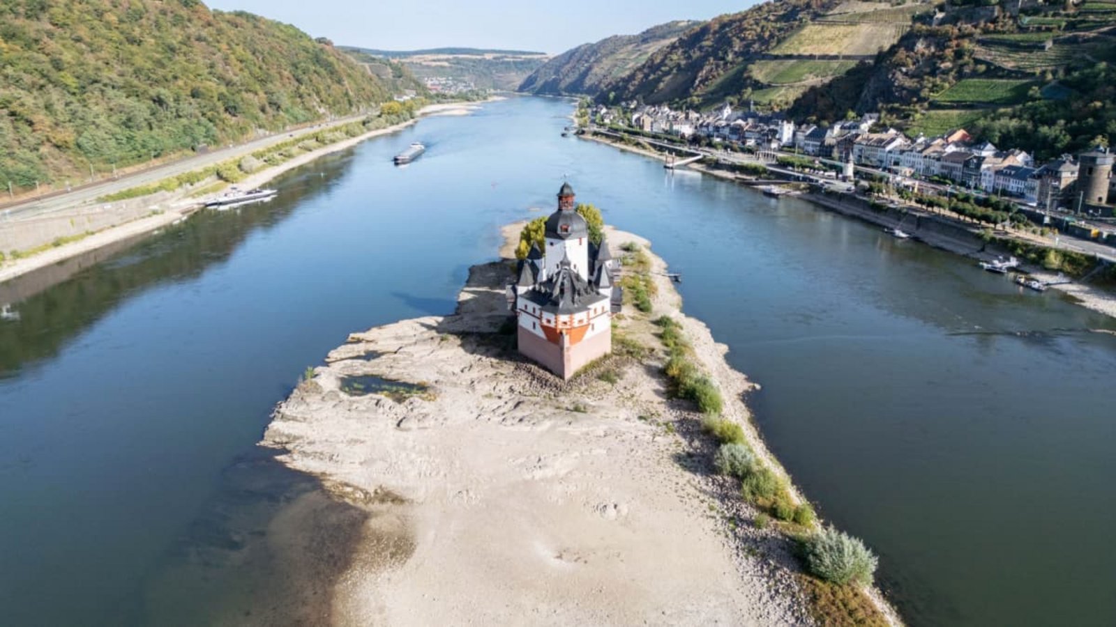 Extremes Niedrigwasser auf dem Rhein lässt an der Festung Pfalzgrafenstein den Grund des Flusses sichtbar werden (Luftaufnahme mit einer Drohne). Die Binnenschifffahrt ist bereits massiv eingeschränkt und droht gänzlich zum Erliegen zu kommen.Boris Roessler/dpa