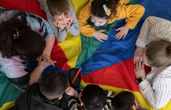 Eine Erzieherin samt Schützlingen in einem Kindergarten.<span class='image-autor'>Foto: dpa/Marijan Murat</span>