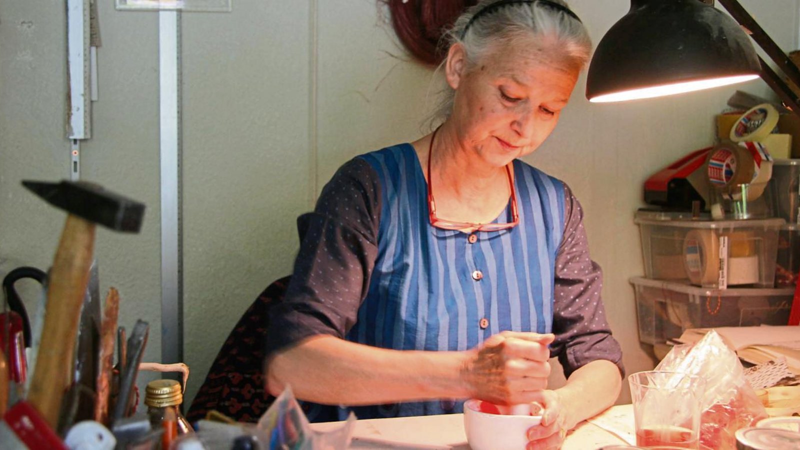 In ihrem kleinen Atelier zerkleinert Annette Wiesner Mohnblüten mit einem Mörser. Aus den roten Blüten wird später eine tiefe, kräftige rote Farbe werden.  Fotos: Thomaser
