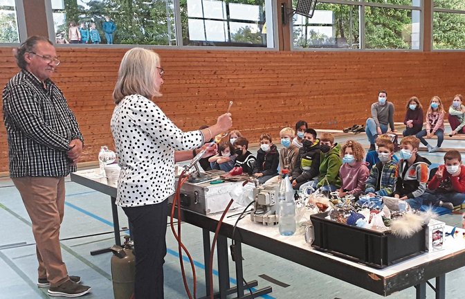 Sabine und Helmut Sommer zeigen den Kirbachschülern anschaulich die traditionelle Handwerkskunst der Glasbläserei.  Foto: Glemser