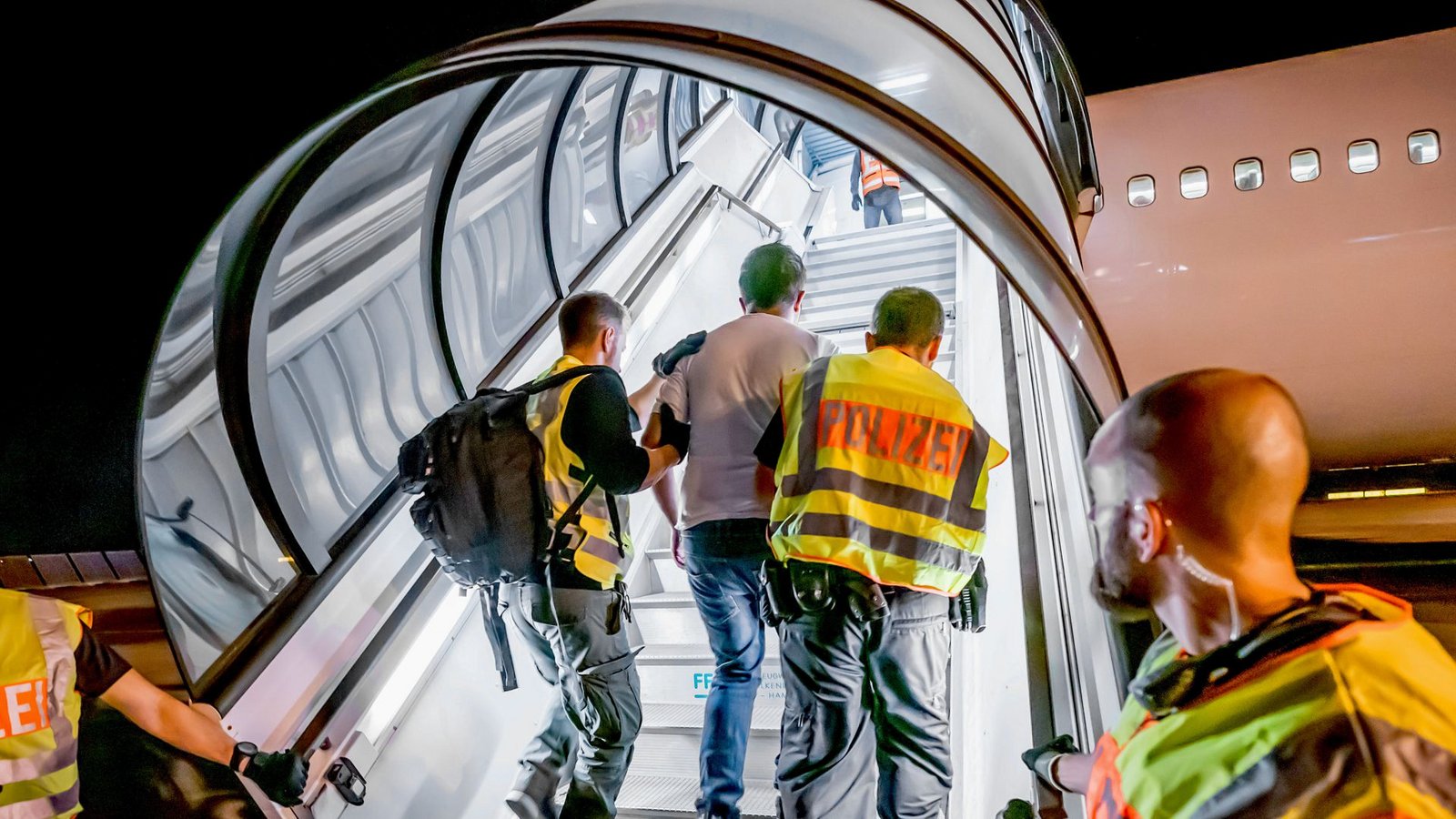 Polizeibeamte begleiten einen Afghanen auf dem Flughafen Leipzig-Halle in ein Charterflugzeug.Foto: picture alliance/dpa/Michael Kappeler Polizeibeamte begleiten einen Afghanen auf dem Flughafen Leipzig-Halle in ein Charterflugzeug.Foto: picture alliance/dpa/Michael Kappeler