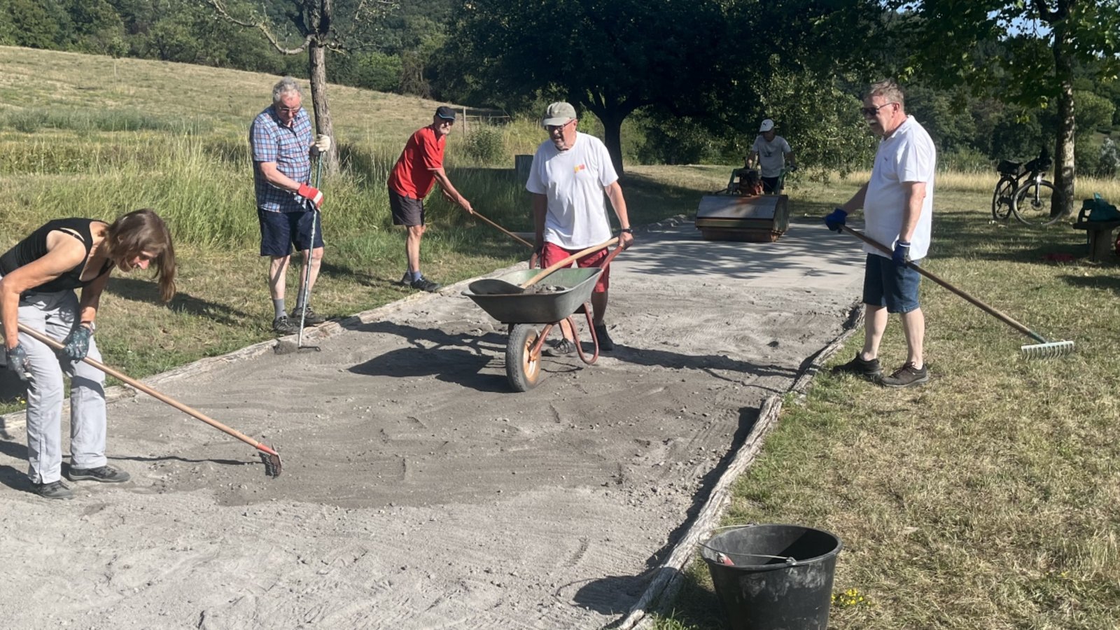 Bei der Arbeit: Ehrenamtliche bringen die Boulebahn in Spielberg in Schuss. Foto: Glemser Bei der Arbeit: Ehrenamtliche bringen die Boulebahn in Spielberg in Schuss. Foto: Glemser