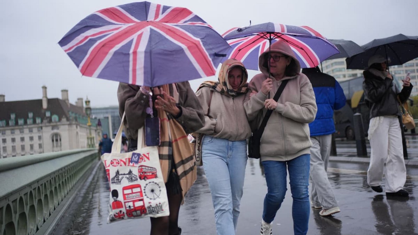 Menschen im Regen auf der Westminster Bridge in London.Yui Mok/PA Wire/dpa Menschen im Regen auf der Westminster Bridge in London.Yui Mok/PA Wire/dpa