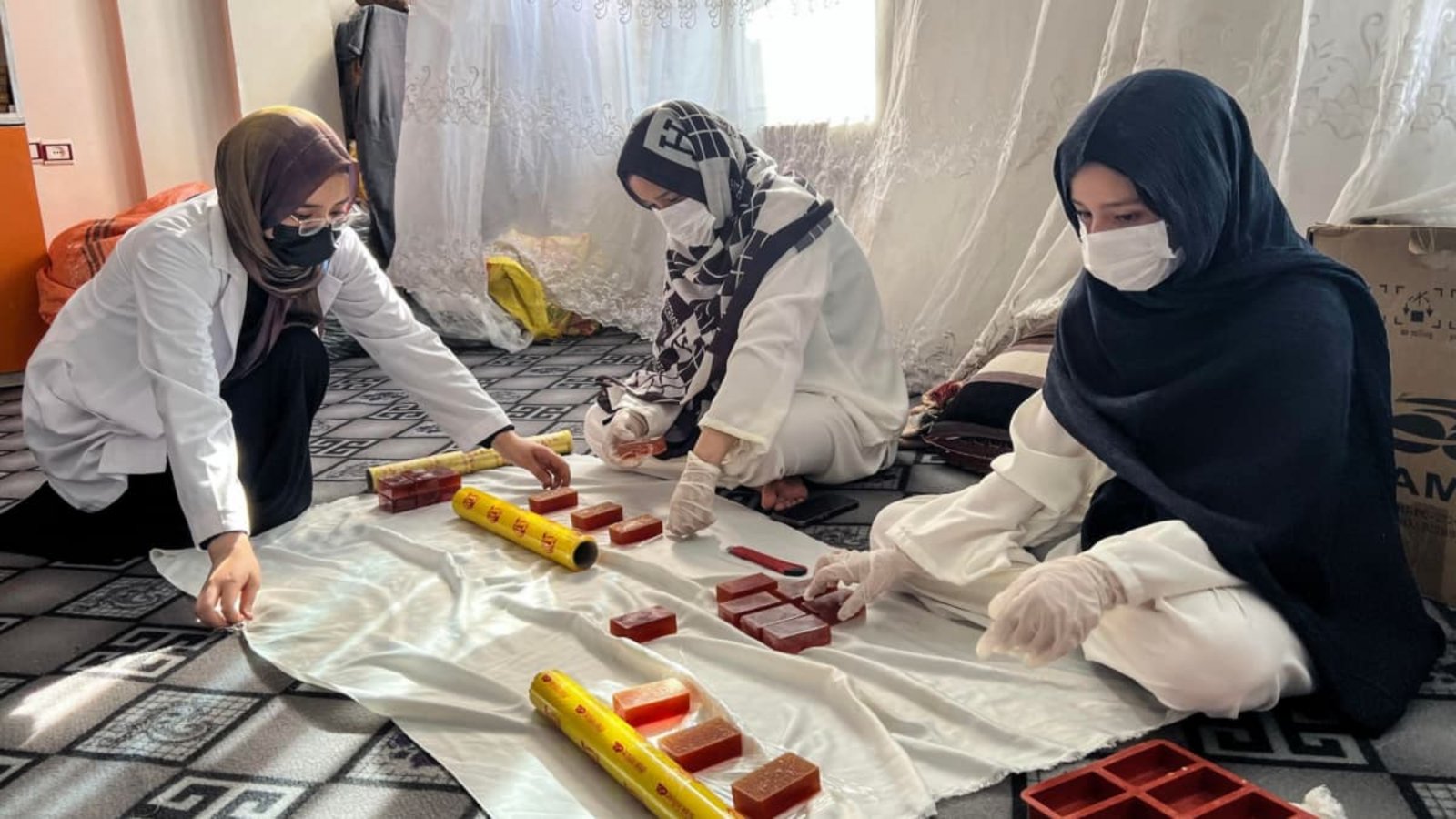 Roqia Rezai (l.) verpackt Seife mit ihren Schwestern in ihrer Seifenfabrik in Herat. Die afghanische Industrie- und Handelskammer erlaubt Frauen teilweise zu arbeiten – wenn sie das von zu Hause aus können.Fardina Akbari/dpa