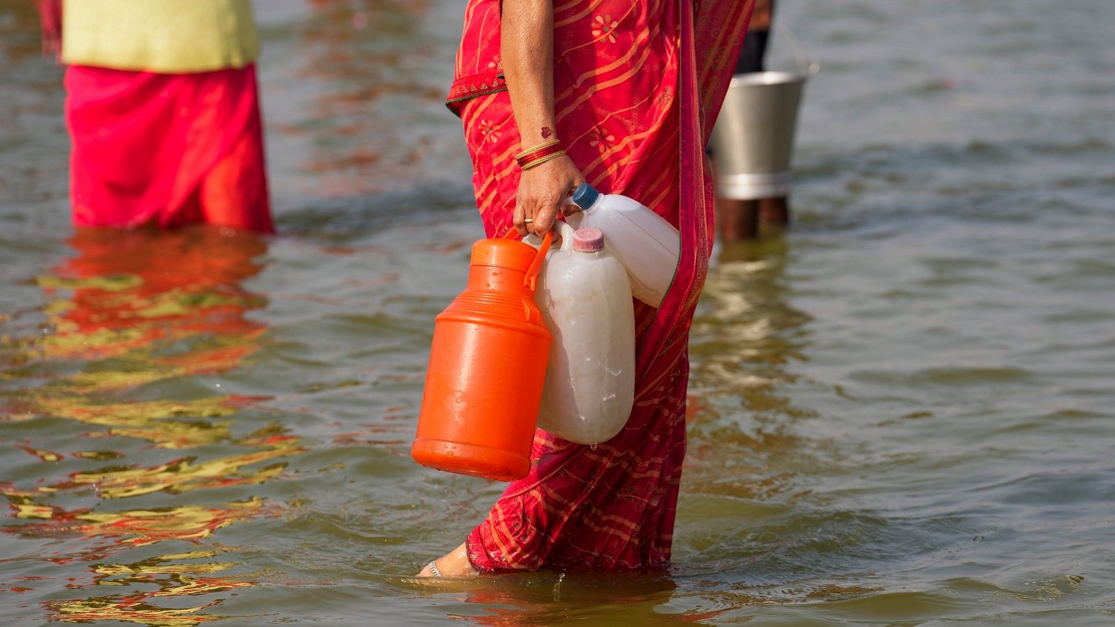 Eine Hinduistin geht nach dem Wasserholen mit Kunststoffkanistern im Sangam, dem Zusammenfluss des Ganges und Yamuna.Foto: Rajesh Kumar Singh/AP