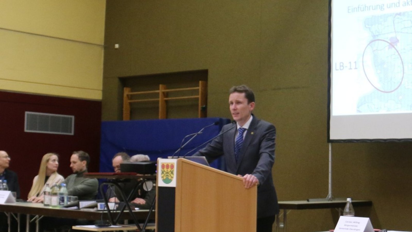 Carsten Willing am Redepult, rechts Michael Schweizer, links die weiteren Experten.