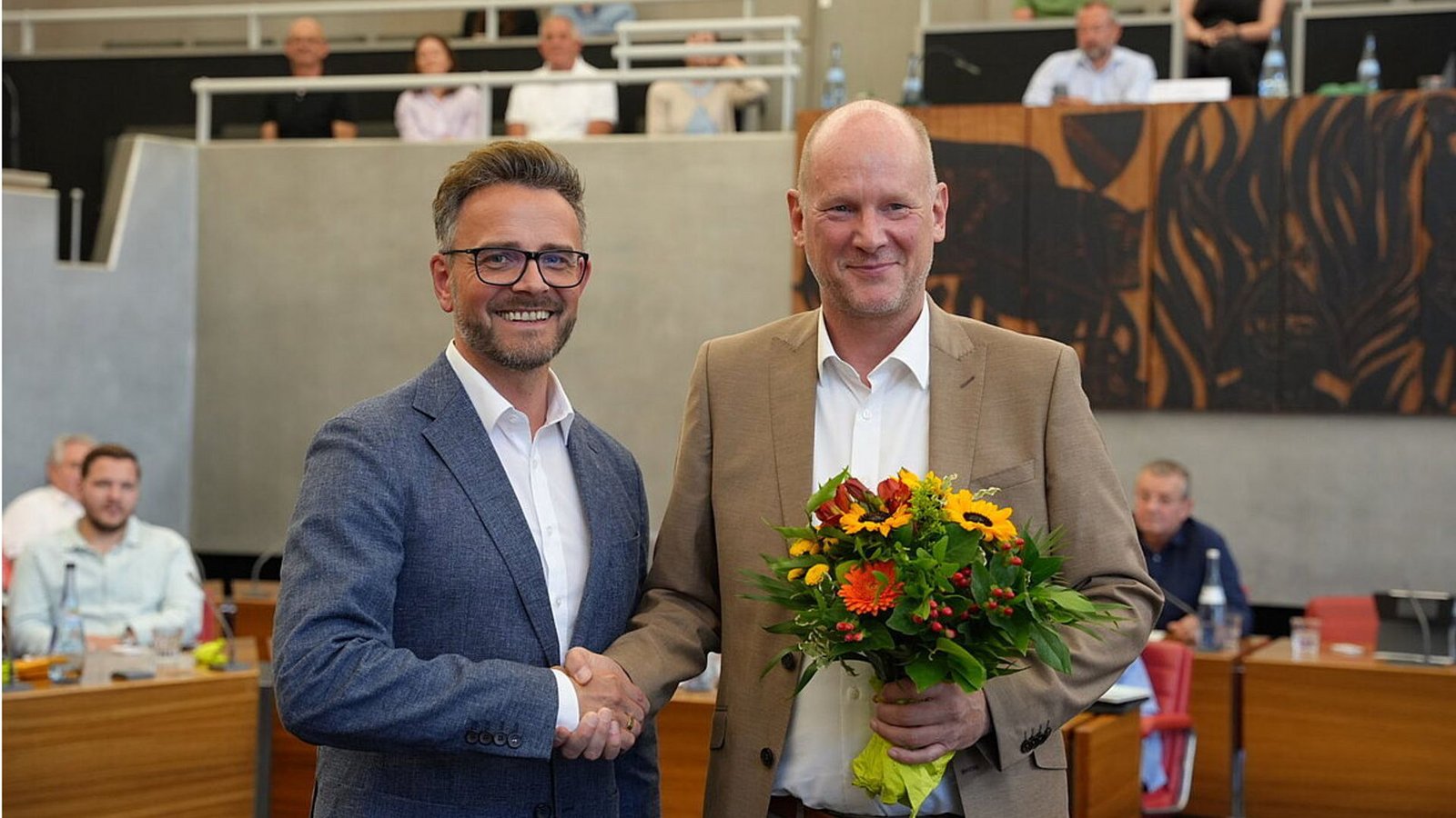 OB Peter Boch (links) gratuliert seinem neuen und alten Stellvertreter Dirk Büscher mit einem Blumenstrauß.Foto: Stadt Pforzheim/oh