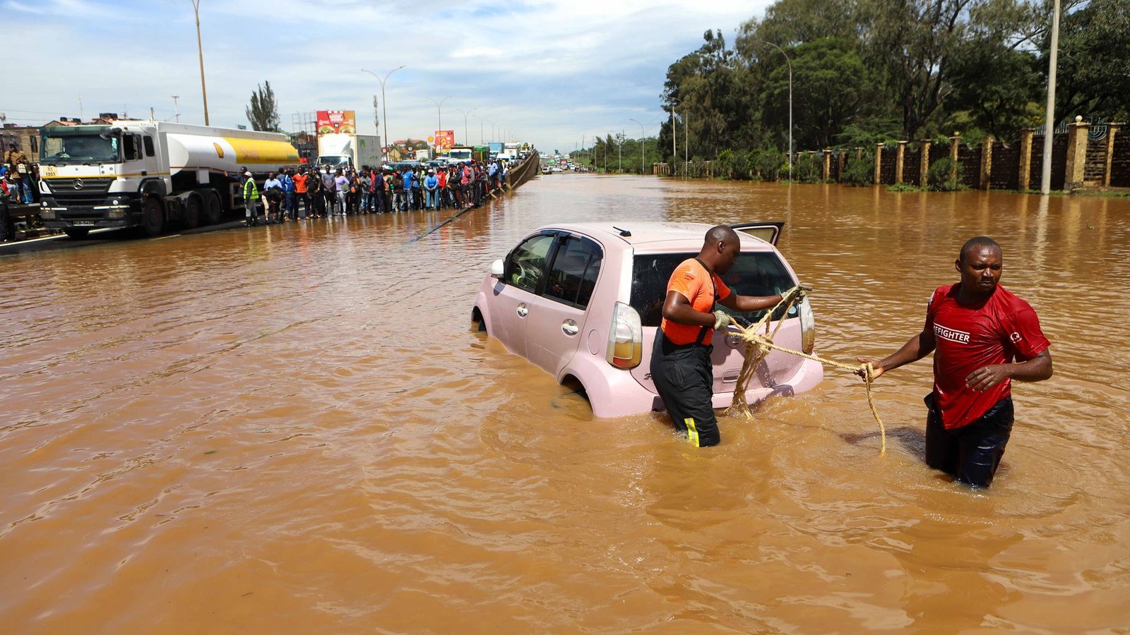 Menschen in Nairobi, die im Hochwasser ein Auto ziehen.Foto: Joy Nabukewa/XinHua/dpa