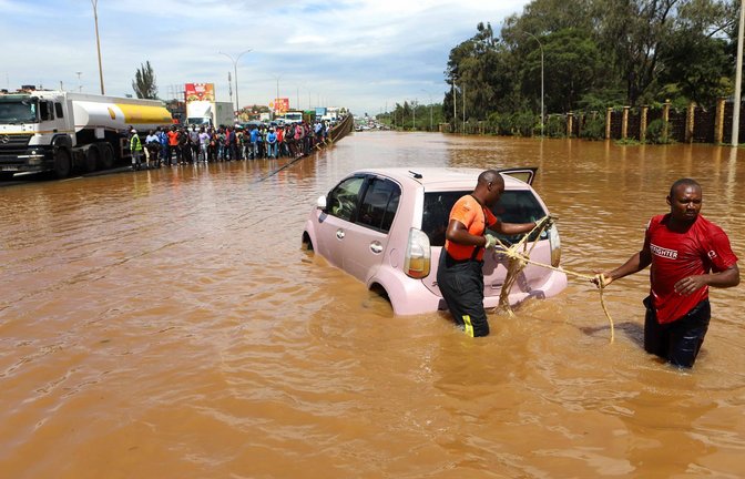 Menschen in Nairobi, die im Hochwasser ein Auto ziehen.<span class='image-autor'>Foto: Joy Nabukewa/XinHua/dpa</span>